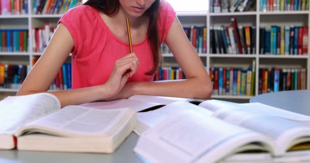 Attente schoolmeisje huiswerk in bibliotheek — Stockvideo