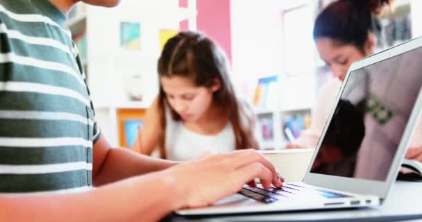 Niños de la escuela haciendo deberes en la biblioteca — Vídeos de Stock