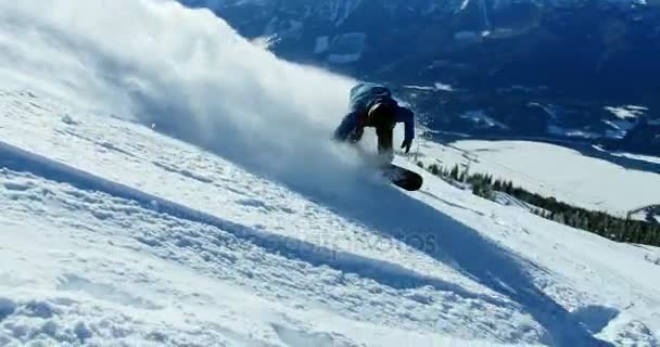 Persoon snowboarden op besneeuwde berg — Stockvideo