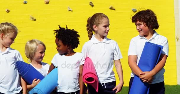 学校の子供たちのヨガマットを押しながらお互いの対話 — ストック動画