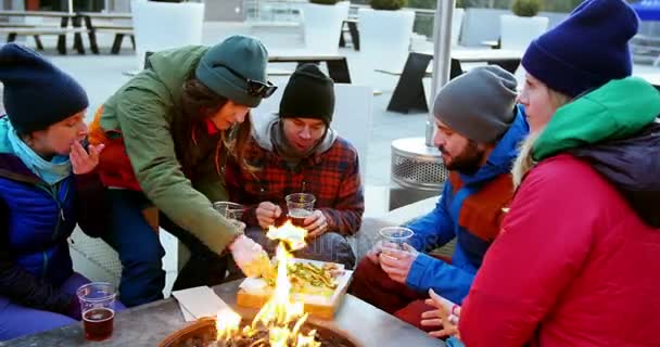 Friends having snacks near campfire — Stock Video