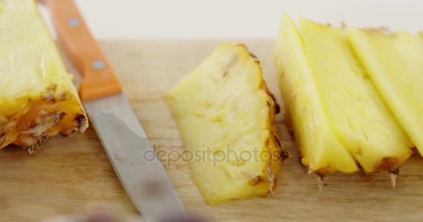 Ломтики и ананасы на деревянном столе — стоковое видео