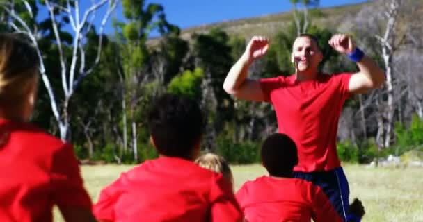 Treinador treinando crianças no campo de treinamento — Vídeo de Stock