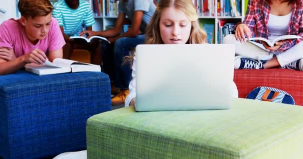 Miúdos da escola a fazer trabalhos de casa na biblioteca — Vídeo de Stock