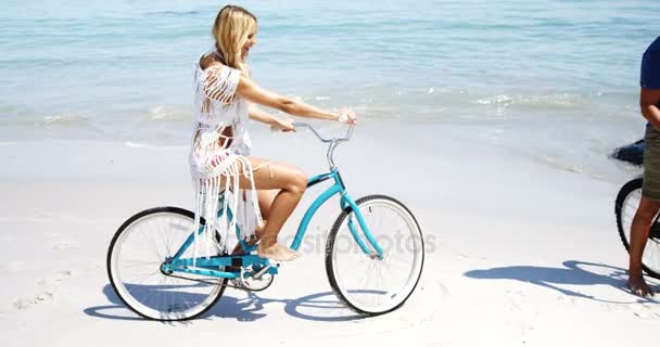 Pareja montando bicicleta en la playa — Vídeos de Stock