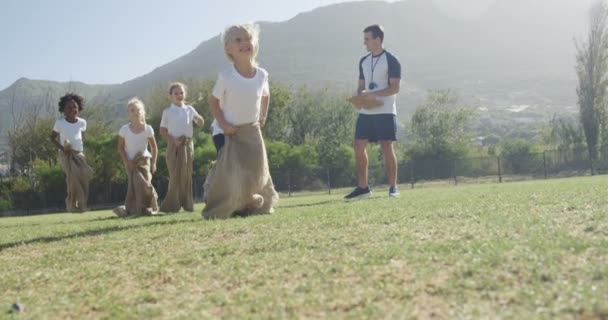 Çocuklar parkta bir çuval yarışı oyun — Stok video