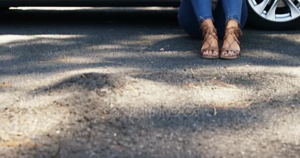 Mujer deprimida sentada cerca del coche — Vídeos de Stock