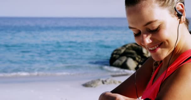 Fit mulher colocando música no telefone celular antes de correr — Vídeo de Stock