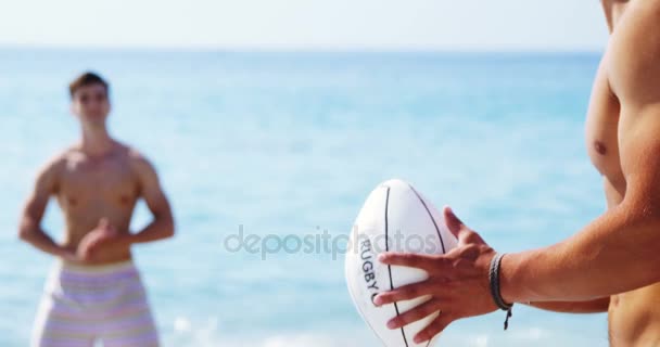 Freunde spielen Rugby am Strand — Stockvideo