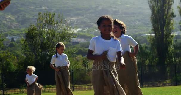 Barn som leker en sack race i park — Stockvideo