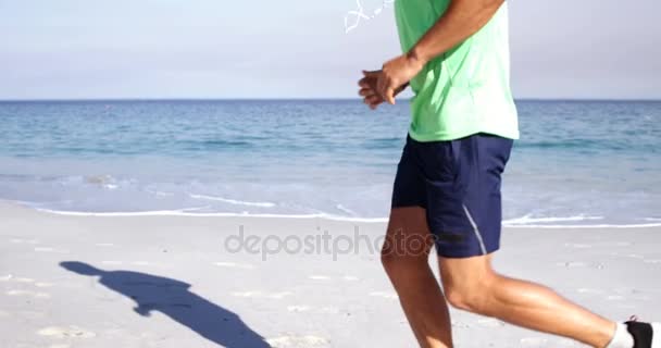 Hombre en forma corriendo en la playa — Vídeo de stock