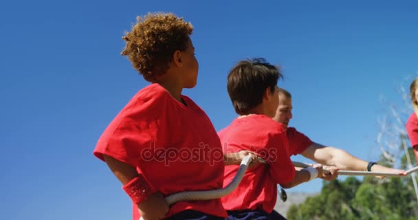 Trainer assisting kids in tug of war — Stock Video