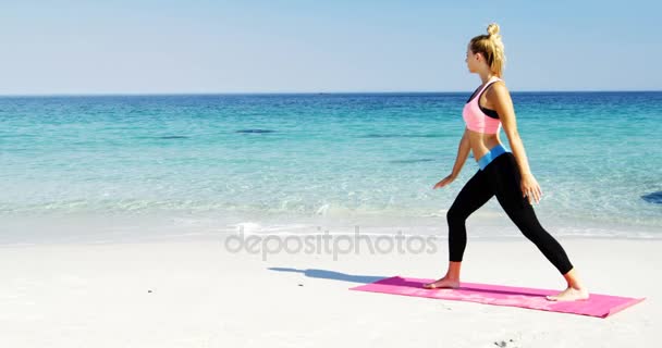 Passar kvinna gör stretching övning på stranden — Stockvideo