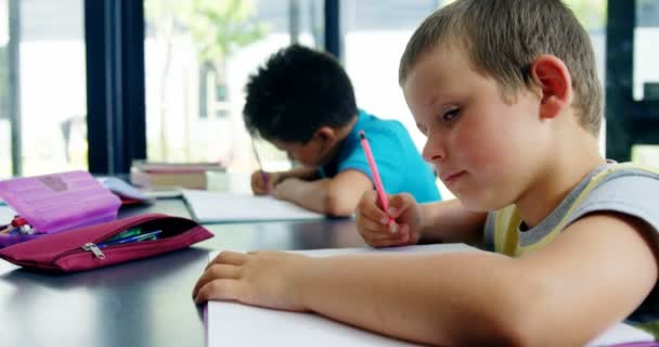 Crianças da escola fazendo lição de casa na sala de aula — Vídeo de Stock