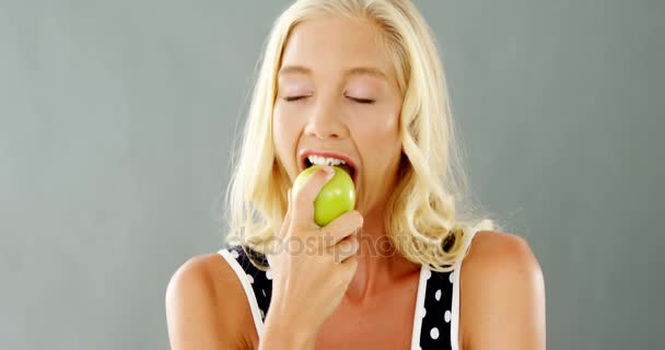 Portret van mooie vrouw eten van groene appel — Stockvideo