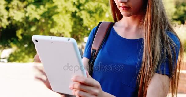 Lachende schoolmeisje met behulp van digitale tablet in campus — Stockvideo
