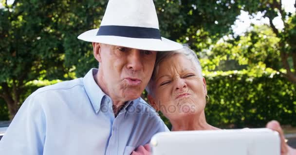 Senior para biorąc selfie formularz telefonu komórkowego w parku — Wideo stockowe