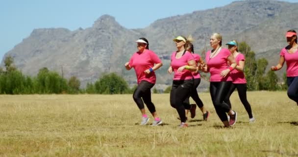 Entrenador que ayuda a las mujeres que corren en el campo de entrenamiento — Vídeos de Stock