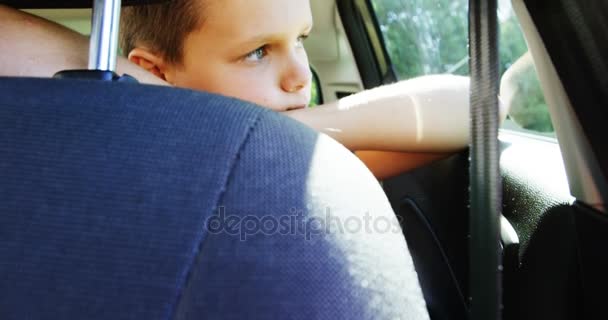 Niño relajándose en el asiento trasero del coche — Vídeo de stock