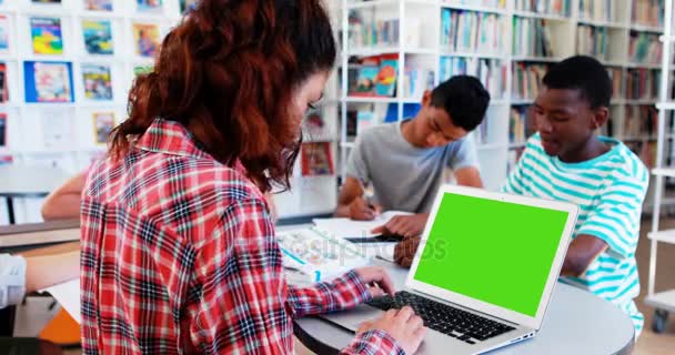 Niños de la escuela haciendo deberes en la biblioteca — Vídeo de stock