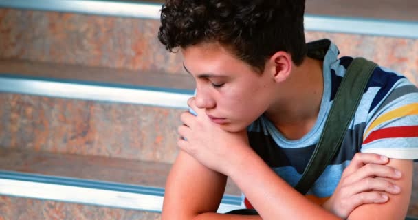 Sorgliga skolpojke sitter ensam på trappan — Stockvideo