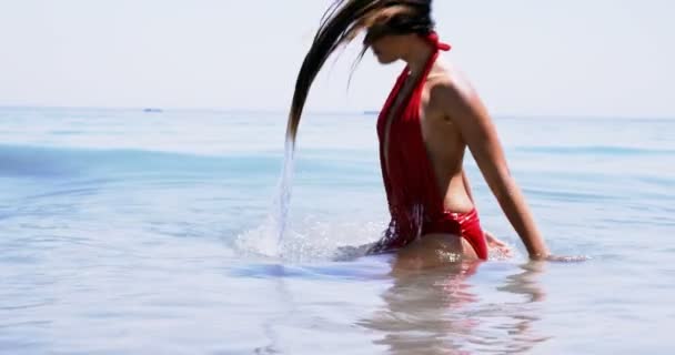 Mulher bonita jogando seu cabelo no ar na praia — Vídeo de Stock