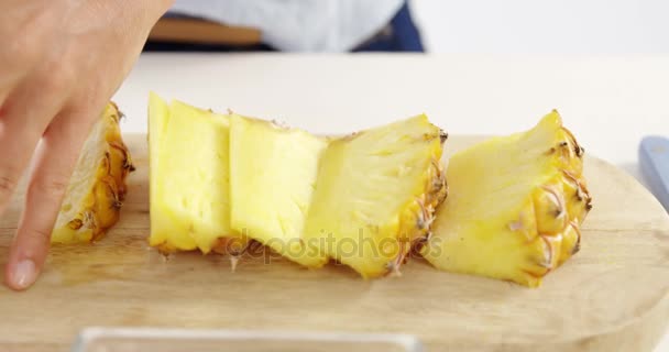 Женщина режет ананас на доске — стоковое видео