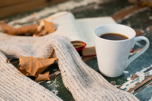 Sweater by open book and coffee cup — Stock Photo, Image