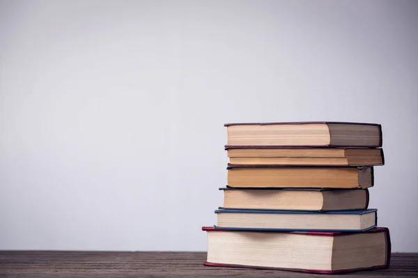 Boeken op tafel tegen muur — Stockfoto