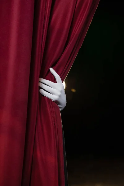 Hand in a white glove pulling curtain away — Stock Photo, Image