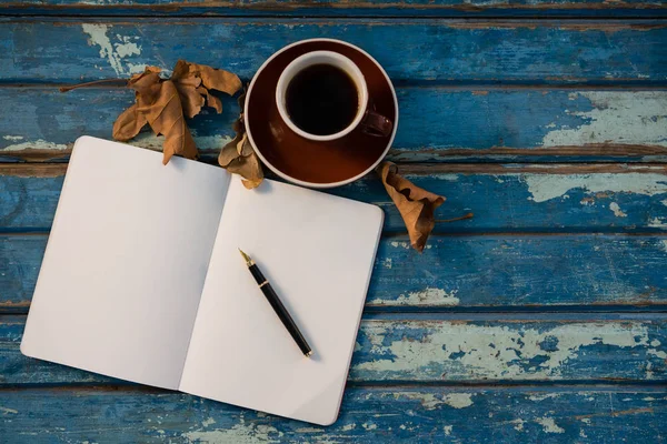 Overhead view of open book by coffee cup — Stock Photo, Image