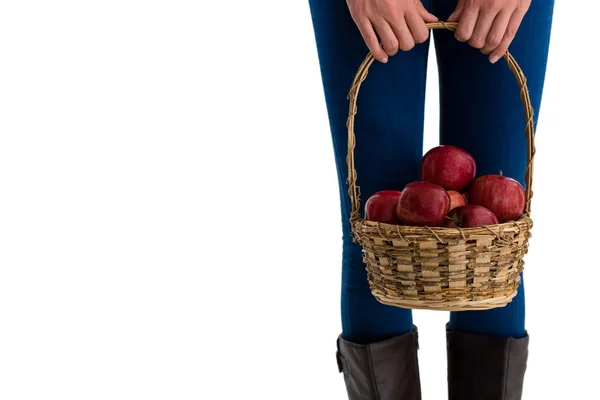Woman holding apples in wicker basket — Stock Photo, Image