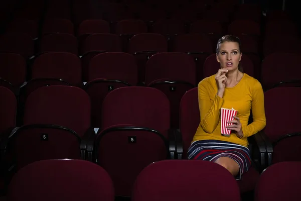 Žena s popcorn při sledování filmu — Stock fotografie