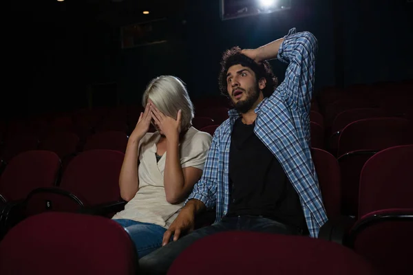 Casal com expressão chocada olhando para o filme — Fotografia de Stock