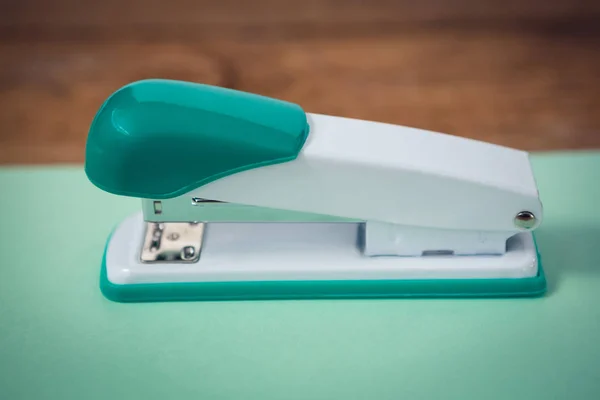 Nietmachine op turquoise papier — Stockfoto