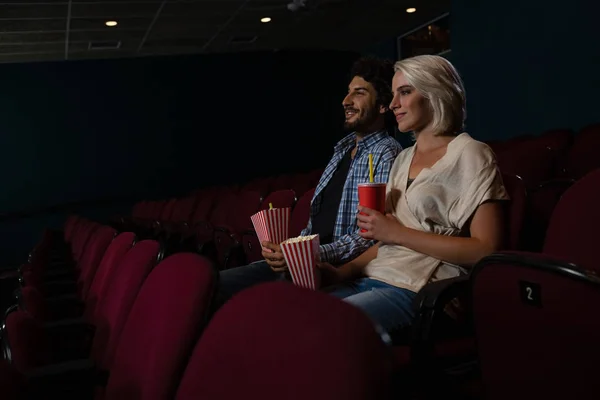 Пара пьет попкорн во время просмотра фильма — стоковое фото