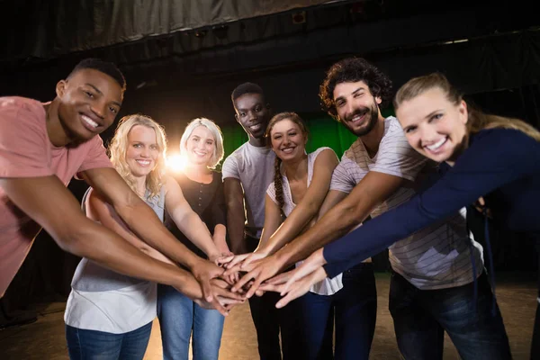Equipe de atores formando suas mãos empilhadas — Fotografia de Stock