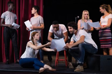 Actors reading their scripts on stage clipart