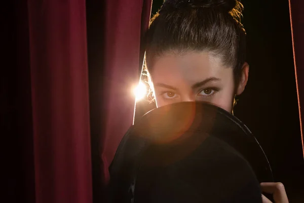 Bailarina de ballet mirando a través de la cortina del escenario — Foto de Stock