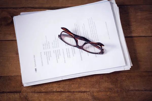 Óculos em documentos à mesa no escritório — Fotografia de Stock