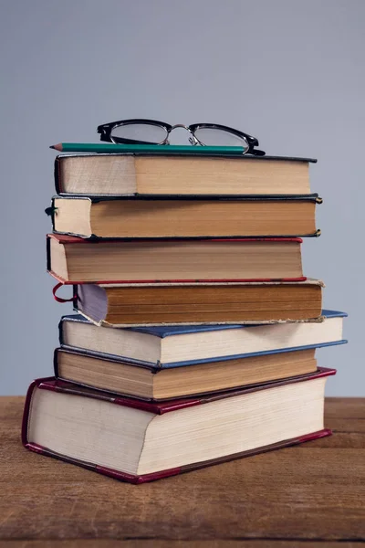 Brýle a tužka na stoh knih — Stock fotografie