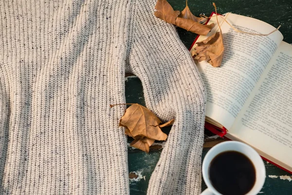 Sweater by open book and coffee cup — Stock Photo, Image