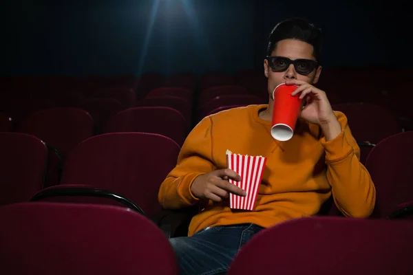 Homem bebendo bebidas enquanto assiste filme — Fotografia de Stock