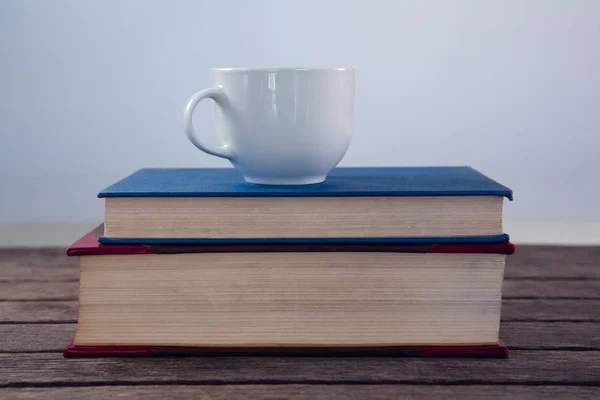 Knihy s šálkem kávy na dřevěný stůl — Stock fotografie
