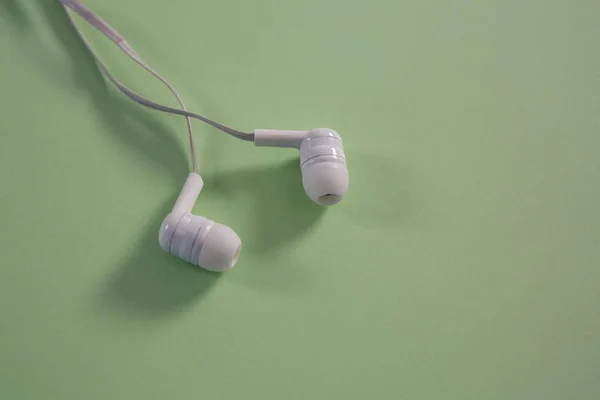 Weiße Kopfhörer auf grünem Hintergrund — Stockfoto