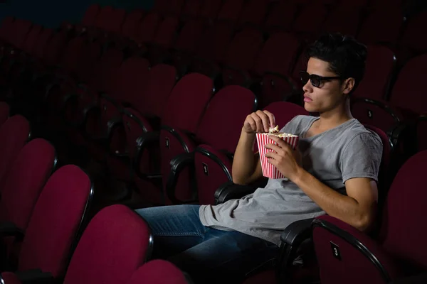 Mann isst Popcorn, während er Film schaut — Stockfoto