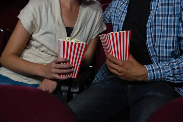 Пара пьет попкорн во время просмотра фильма — стоковое фото