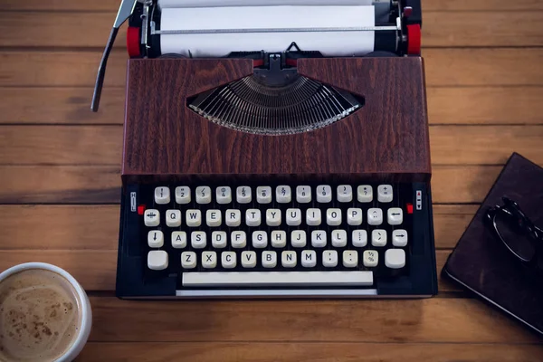 Schrijfmachine door koffiekopje en een boek — Stockfoto