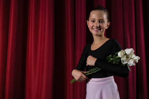 Ballerina poseren met bloemboeket op het podium — Stockfoto