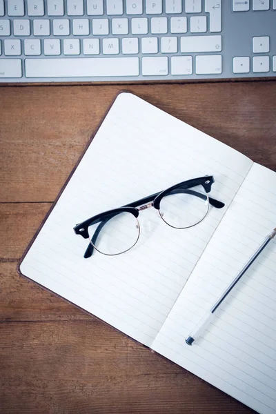 Tagebuch mit Stift und Brille per Tastatur — Stockfoto